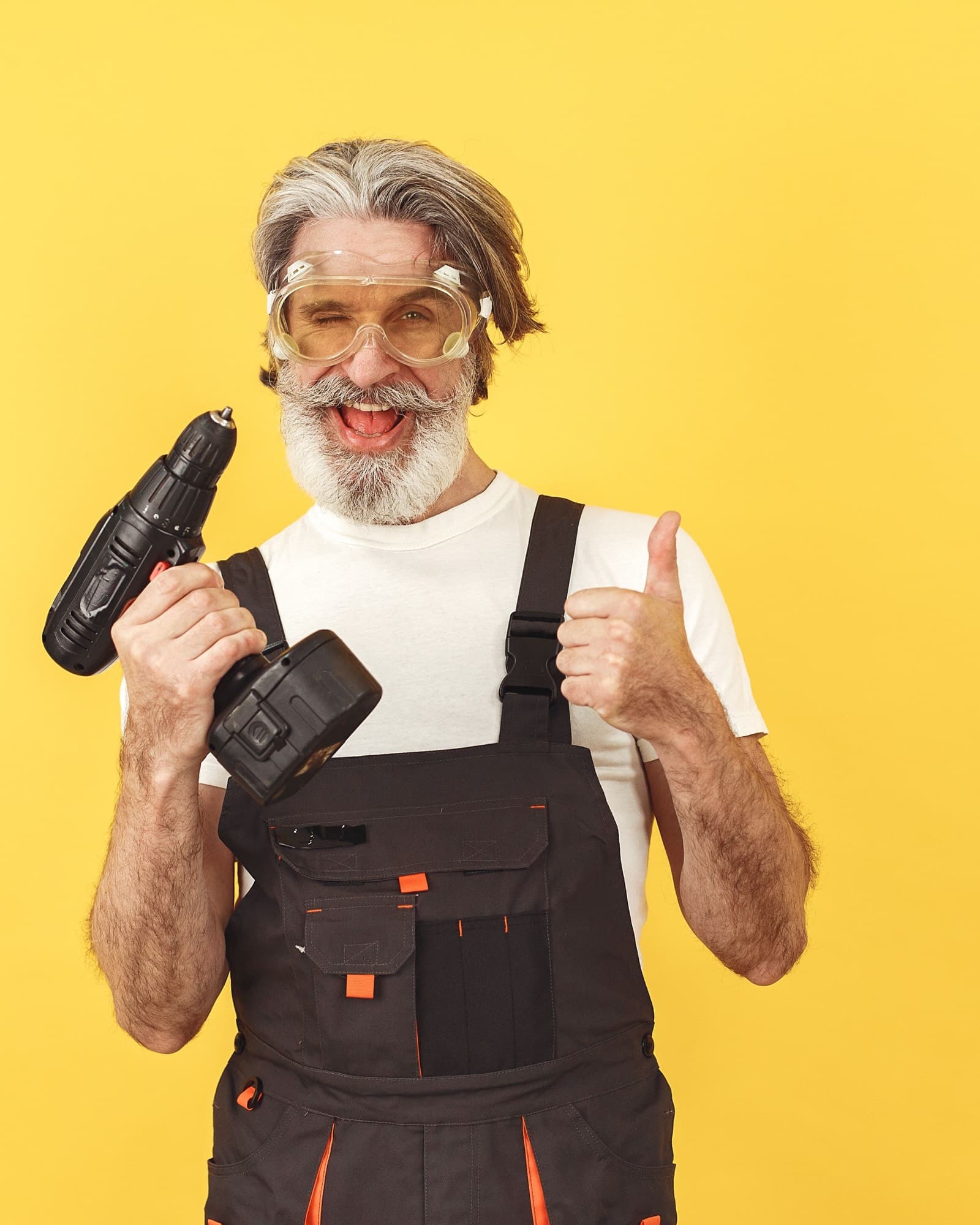 Smiling tradesperson in workwear holding a cordless drill